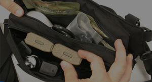 Person shuffling through casualty care equipment bag.