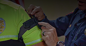 Officer adjusting touniquet on another officer.